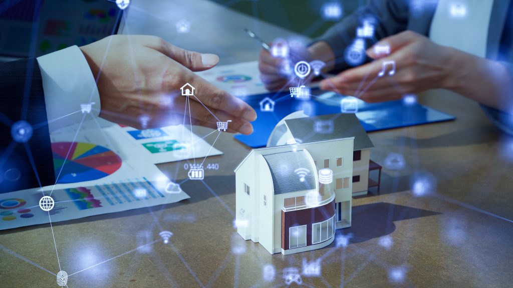 smart technology icons overlaid on small house model and hands of people talking